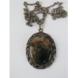 A large and impressive hallmarked silver natural moss agate pendant in floral setting,