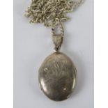 A silver locket having part floral engraving and stamped 925 on a HM silver chain,