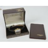 A c1980s Longines gold plated wristwatch on black reptile calf strap, with box and papers.