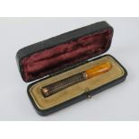A superb 9ct rose gold and guilloche enamelled cigarette holder / cheroot having amber mouthpiece