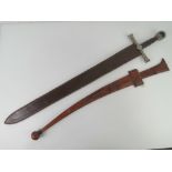 A Sudanese sword with double edged steel blade and leather hilt with matching leather scabbard.