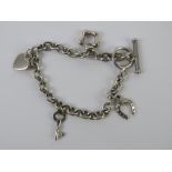 A HM silver charm bracelet having T-bar clasp and four charms upon being daisy, heart,