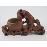 A Chinese soap stone brush pot, carved and pierced and bearing monkey figuring upon, 14cm wide.