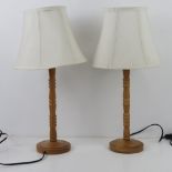 A pair of contemporary turned wooden table lamp bases with matching shades.