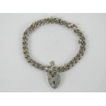 A HM silver heavy curb link bracelet having heart padlock clasp,