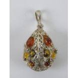 A silver and Baltic amber pendant in the form of a hinged egg, stamped 925, 4.5cm inc bale.