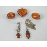 Three Baltic amber and silver pendants, one in Celtic style,