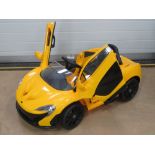 A battery operated childs McLaren P1 car in yellow, in 'as new' boxed condition,