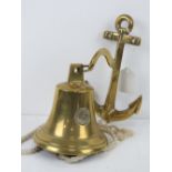 A brass wall mounted bell having anchor shaped wall mounting,