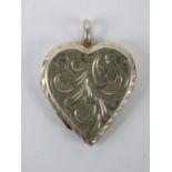 A HM silver locket in the form of a heart having scrolling vine engraving to front,