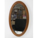 An Edwardian oval bevelled edge wall mirror,