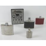 Four stainless steel hip flasks together with a bottle opener set with three stoppers. Five items.