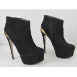 A pair of black velvet platform ankle bo