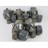 A quantity of Finnish M61 gas masks with filters; one being size 1 and four being size 2.