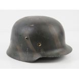 A reproduction WWII German M40 helmet with liner and chin strap.