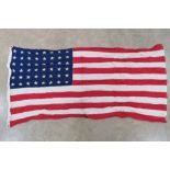 A US flag having 48 stars upon, sewn fabric stripes, printed stars and measuring 145 x 80cm.