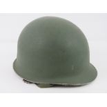 A WWII US helmet having liner and chin strap.