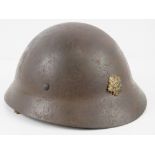 A WWII Japanese Police helmet with liner, chin strap and bearing Japanese writing within.