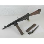 A deactivated Sten MK V 9mm sub machine gun with bayonet and spare magazine having moving cocking