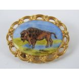 A HM silver and enamel brooch having buffalo upon, gilded,