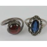 Two white metal rings, one with red cabachon size N,