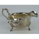 A Mappin & Webb HM silver sauce boat raised over three hoof feet,