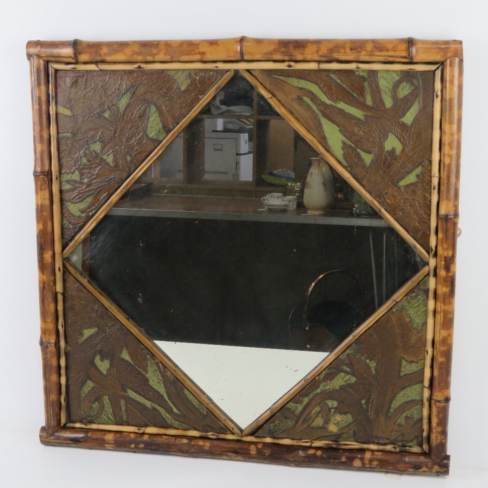 A late 19thC English Aesthetic Movement bamboo and embossed leather framed mirror,