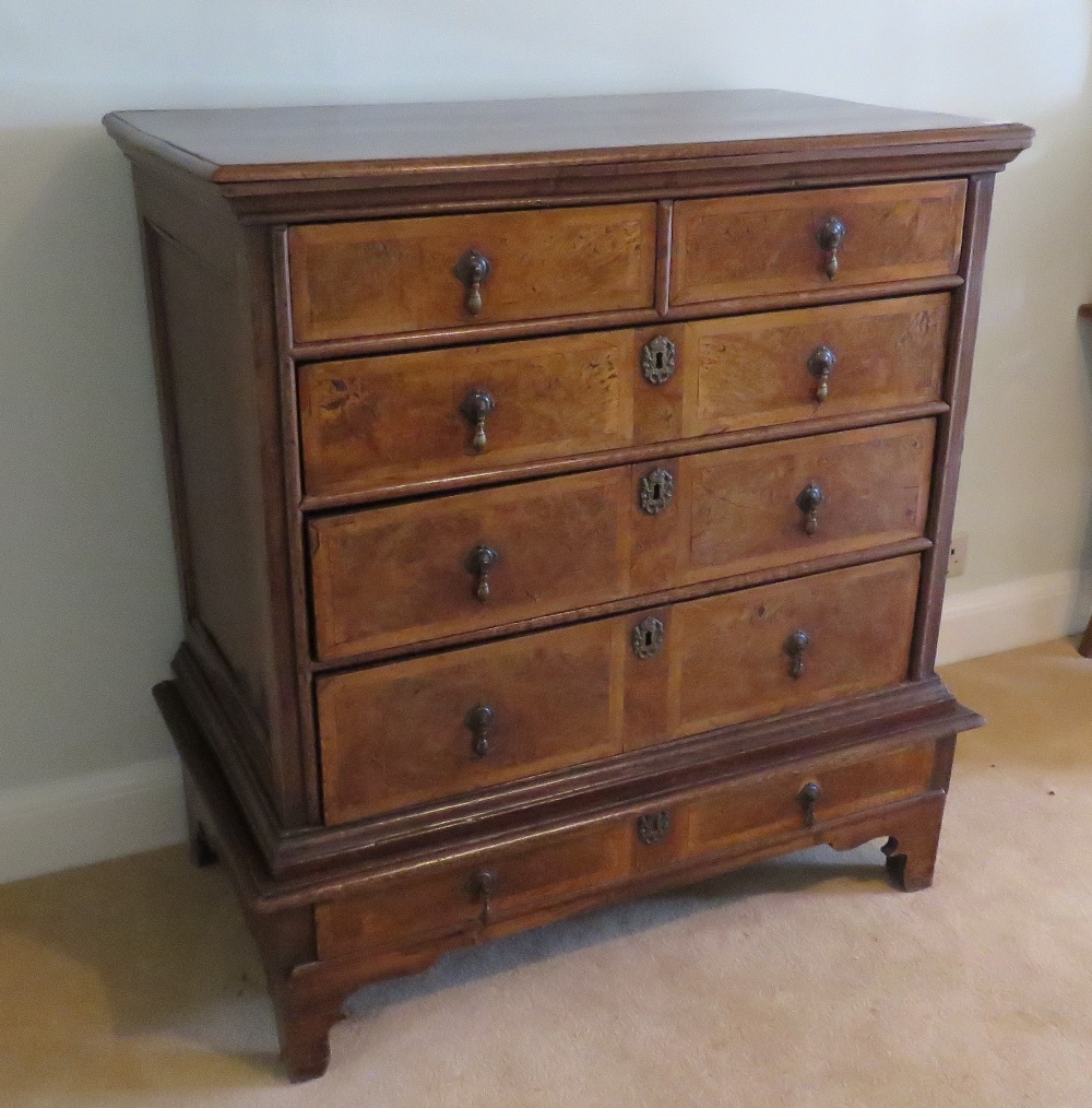A fine walnut and oak chest on stand being two short over three long drawers to the upper section,