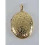 A large 9ct gold locket having floral engraving to front, 4.