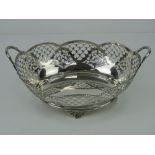A HM silver twin handled fruit bowl having pierced decoration and raised over four floral feet,