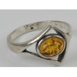 A silver and Baltic amber ring having central oval cabachon in open triangular setting, stamped 925,