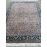 A woollen and silk blush pink ground rug with geometric decoration upon, measuring 242 x 166cm.