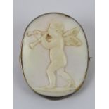 An 'angel skin' coral carved cameo in the form of a cherub playing a musical instrument,