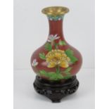 A single early 20th century cloisonné floral vase raised over Oriental hardwood stand, 16cm high.