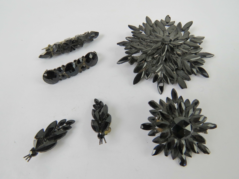 Four French jet brooches, one with matching pair of clip on earrings.