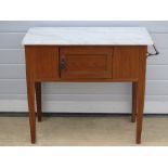 An Edwardian stained pine washstand with end towel rail and single cupboard door with white marble