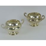 A pair of HM silver salts, each raised over single pedestal foot with twin handles,