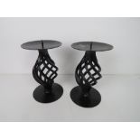 A pair of black painted metal candle stands, each 16.5cm high.
