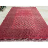 A red ground woollen rug having geometric pattern upon,