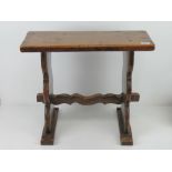 An early 20th century joint stool in oak, plank top and supports united by shaped trestle stretcher,