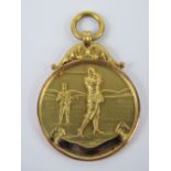 A 9ct gold unengraved golfing themed medallion, hallmarked for Birmingham,