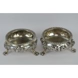 A pair of Victorian HM silver salts having floral decoration and each raised over three lions paw