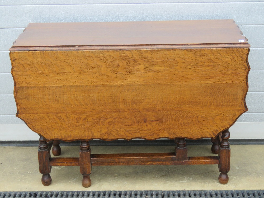 A substantial oak drop leaf table having unusual shaped top over barley twist base with gate legs - Image 2 of 2