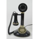 A contemporary black plastic 'candlestick' telephone.