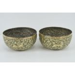 A pair of repoussé brass bowls having foliate decoration with birds and hunting dogs upon,