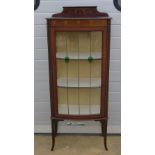 An Edwardian glazed display cabinet having door opening to reveal shelves within,