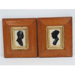 A pair of 19th century silhouettes heightened with chalk, each presented in birds-eye maple frames,
