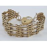 A 9ct gold seven row gate link bracelet with heart padlock clasp, hallmarked 375, 18g.