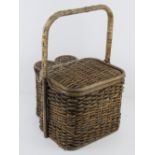 A vintage picnic hamper inc two wine bottle compartments, opening to reveal plastic cutlery, plates,