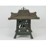 A cast metal candle stand in the style of an Oriental pagoda 26 x 26 x 24cm.